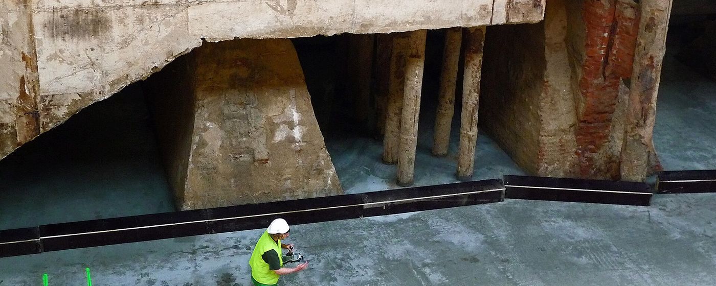 An engineer inspecting the foundations beneath a city building