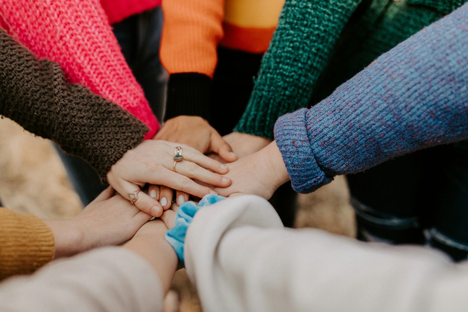 A diverse team stacking their hands together in a show of unity